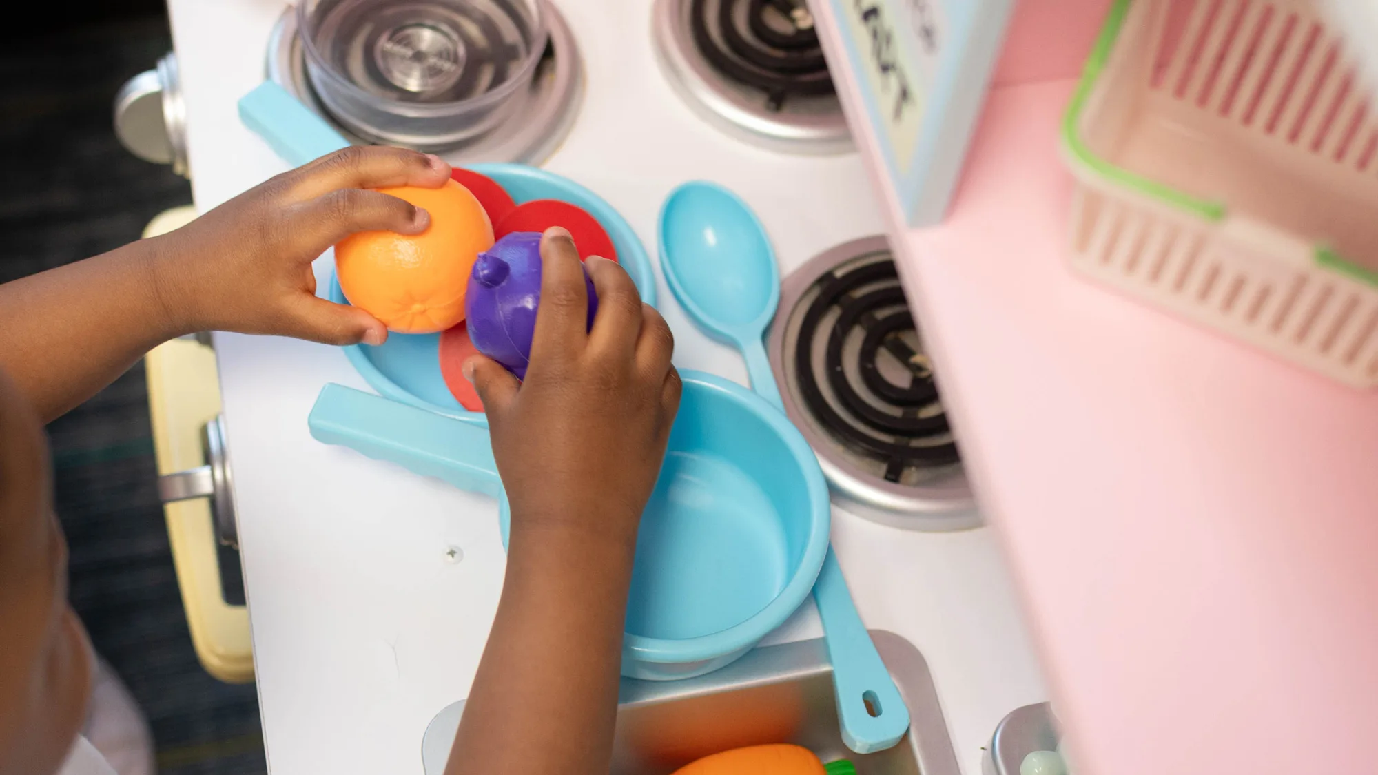 little hands holding plastic fruit